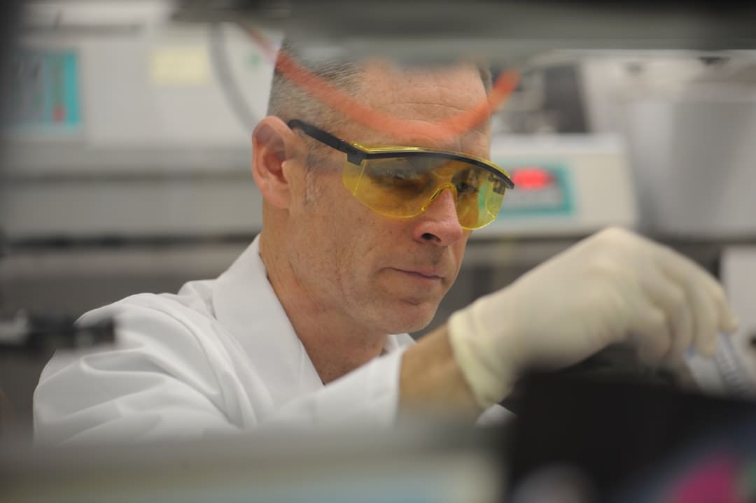 oxytocin brain chemistry. A man in a lab wearing safety goggles