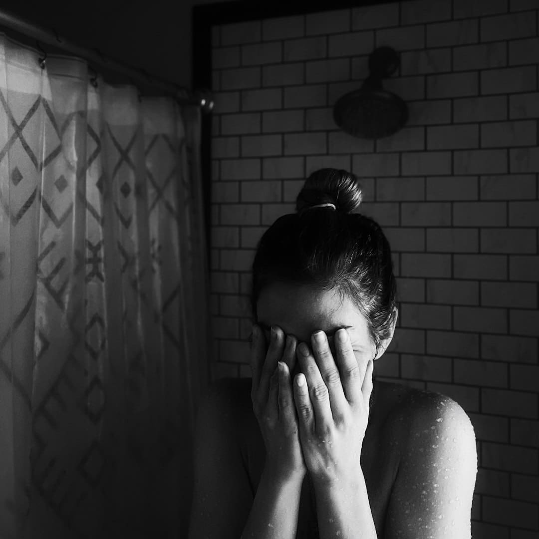 anxiety support animal — grayscale photo of woman covering her face with her hands