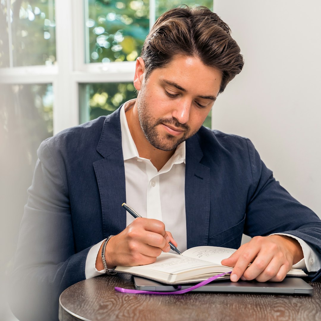 petting a dog lowers cortisol — man in blue suit jacket holding white tablet computer